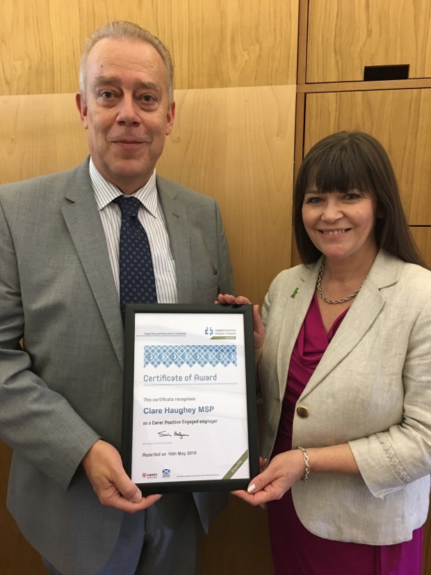 Simon Hodgson of Carers Scotland presenting accreditation to Clare Haughey MSP